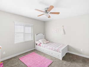 Carpeted bedroom featuring ceiling fan