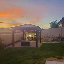 Yard at dusk featuring a patio and a gazebo