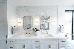 Bathroom with dual bowl vanity, a stand alone, and full height backsplash