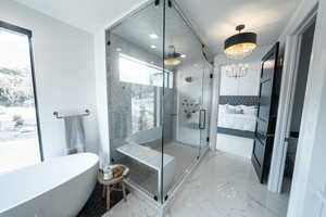 Bathroom with a shower, a chandelier, and tile flooring