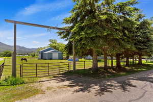 Exterior space featuring an outdoor structure, a front yard, and a mountain view