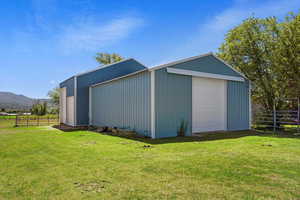 View of outdoor structure featuring a garage and a yard