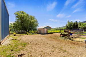 View of yard with an outdoor structure and a rural view