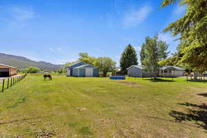 View of yard featuring a mountain view, an outdoor structure, and a rural view