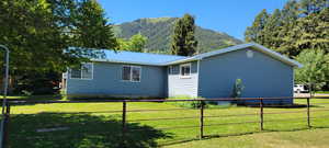 View of side of home with a yard and a mountain view