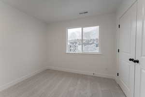 Empty room with a mountain view and light colored carpet