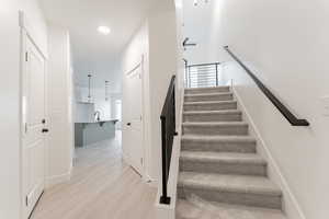 Staircase with hardwood / wood-style floors and sink