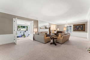 Formal living room featuring crown molding, chandelier and fireplace.