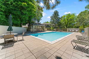 View of swimming pool with an outdoor structure and a patio.