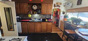 Kitchen featuring dark hardwood / wood-style floors, dishwasher, sink, and backsplash