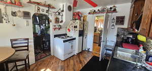 Kitchen featuring sink, white appliances, dark wood-type flooring, and ceiling fan