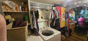 Clothes washing area featuring independent washer and dryer and wood-type flooring