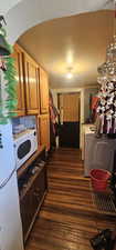 Clothes washing area featuring dark wood-type flooring