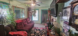 Carpeted living room with ceiling fan