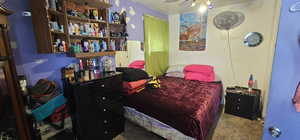 Carpeted bedroom featuring ceiling fan