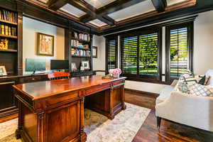 Office area featuring ornamental molding, beamed ceiling, hardwood / wood-style floors, built in desk, and coffered ceiling