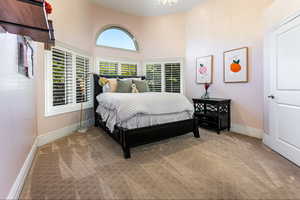 Bedroom featuring carpet flooring and a towering ceiling