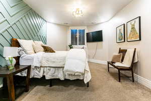 Bedroom featuring carpet flooring and a chandelier