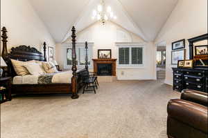 Bedroom with carpet, high vaulted ceiling, and a chandelier