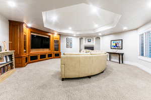 Living room featuring carpet, a tray ceiling, and crown molding