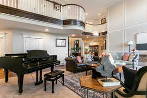 Living room with a high ceiling, light hardwood / wood-style floors, and ornamental molding