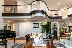 Living room featuring a towering ceiling and hardwood / wood-style flooring