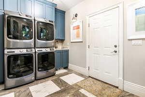 Laundry room featuring cabinets, sink, stacked washer and dryer, and light tile floors