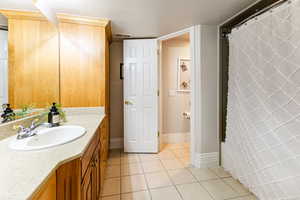 Bathroom with tile flooring, a textured ceiling, and vanity