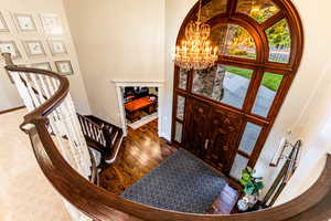 Entrance foyer featuring a notable chandelier, a high ceiling, and hardwood / wood-style floors