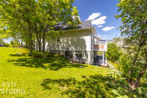 View of side yard featuring central AC and a balcony