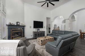 Living room featuring ornamental molding, dark wood-type flooring, ceiling fan, and a high end fireplace