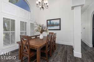 Dining room featuring a notable chandelier, crown molding, and dark wood-type flooring