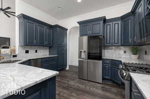 Kitchen featuring stainless steel appliances, dark hardwood / wood-style floors, sink, tasteful backsplash, and ceiling fan