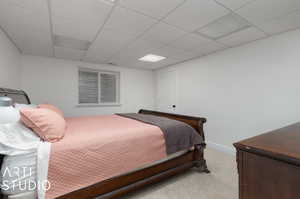 Carpeted bedroom featuring a paneled ceiling