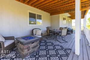 Wooden deck with an outdoor living space with a fire pit