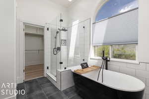 Bathroom featuring tile floors, ornamental molding, tile walls, and independent shower and bath