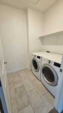 Clothes washing area featuring independent washer and dryer and light tile floors