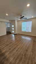 Living room with ceiling fan, a textured ceiling, and light wood-type flooring