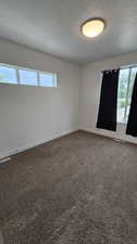 Unfurnished room featuring carpet flooring and a textured ceiling