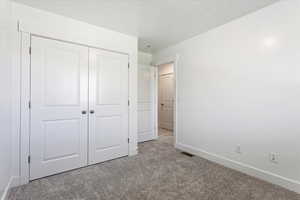 Unfurnished bedroom featuring a closet and carpet flooring