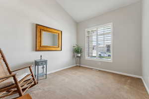 Unfurnished room with vaulted ceiling and light colored carpet