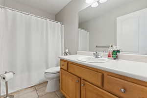 Bathroom with tile flooring, vanity, and toilet