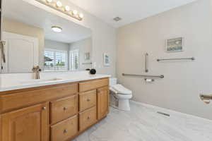 Bathroom featuring tile floors, vanity, and toilet