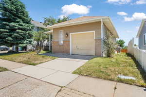 Exterior space featuring a front yard, an outdoor structure, and a garage