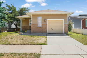 View of front of property featuring a garage and a front yard