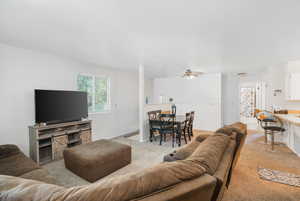 Living room featuring carpet and ceiling fan