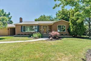 Ranch-style house with a garage and a front lawn