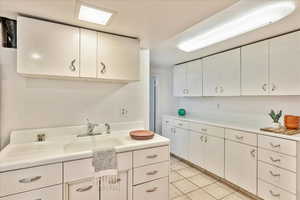 Kitchen featuring white cabinetry and light tile flooring