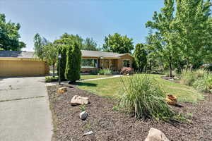 Single story home with a garage and a front yard