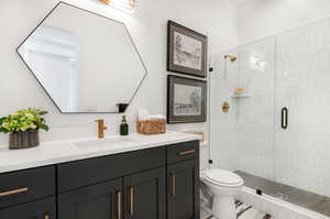 Bathroom featuring an enclosed shower, toilet, and vanity